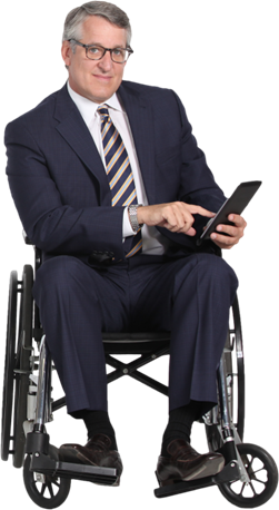 Man in suit and tie with smartphone sitting in wheelchair.